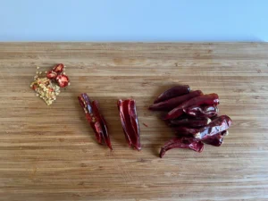 Chopped dry Cayenne Peppers with seeds removed laying on a wooden board.